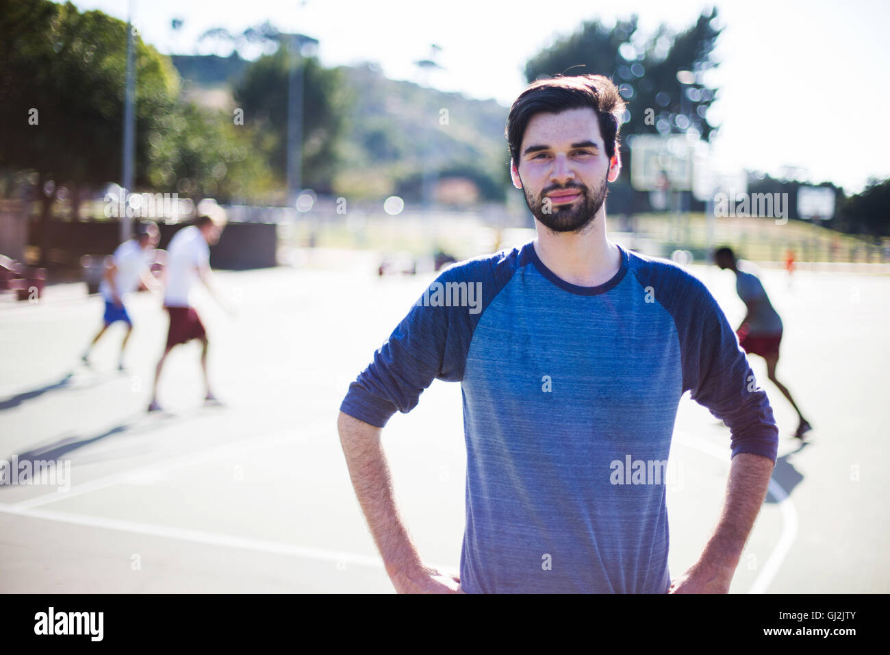 Porträt des jungen Mannes am Basketballplatz Stockfoto