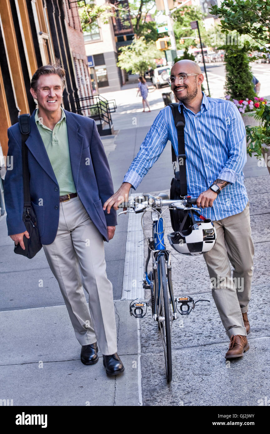 Geschäftsleute auf Straße, Mitte erwachsener Mann schob Fahrrad, lächelnd Stockfoto