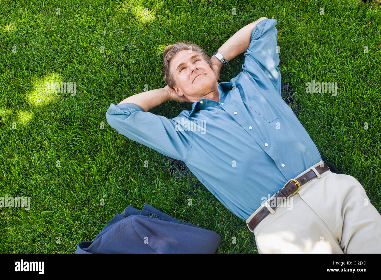 Geschäftsmann entspannend auf Rasen Stockfoto