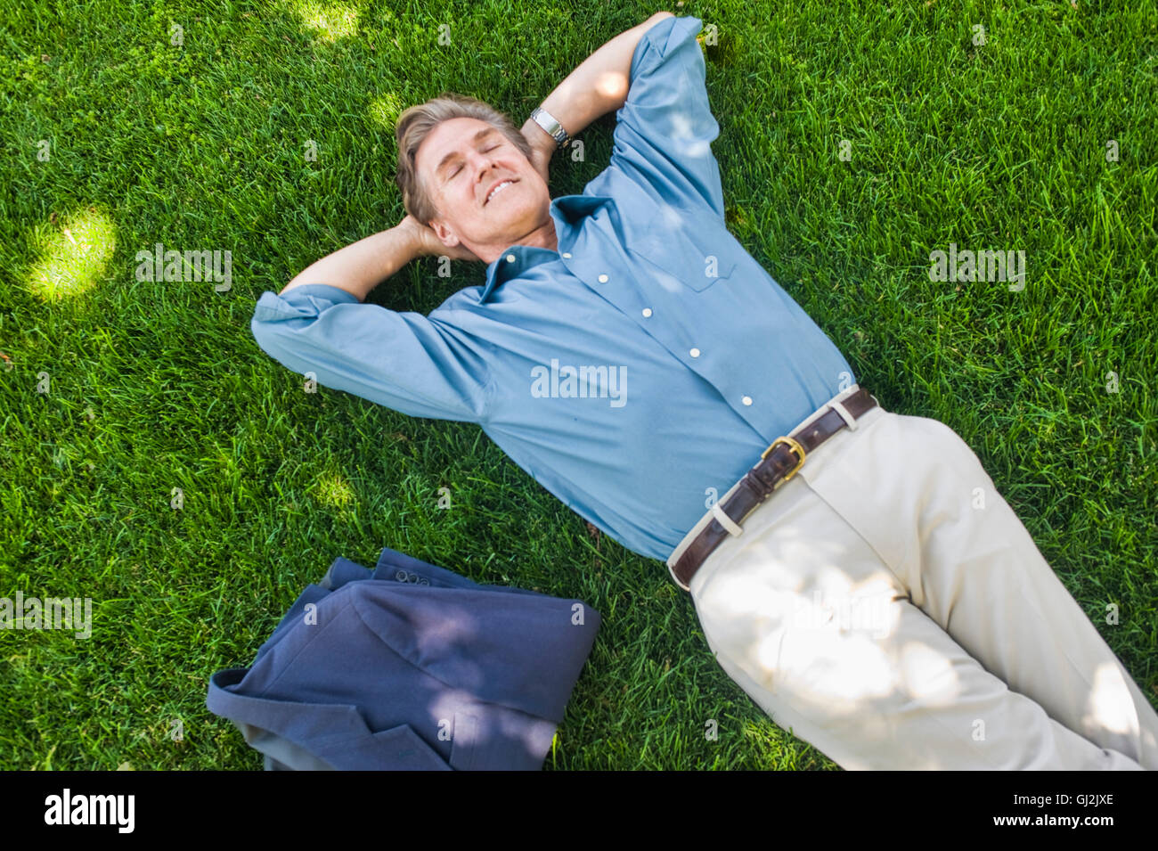 Geschäftsmann entspannend auf Rasen Stockfoto
