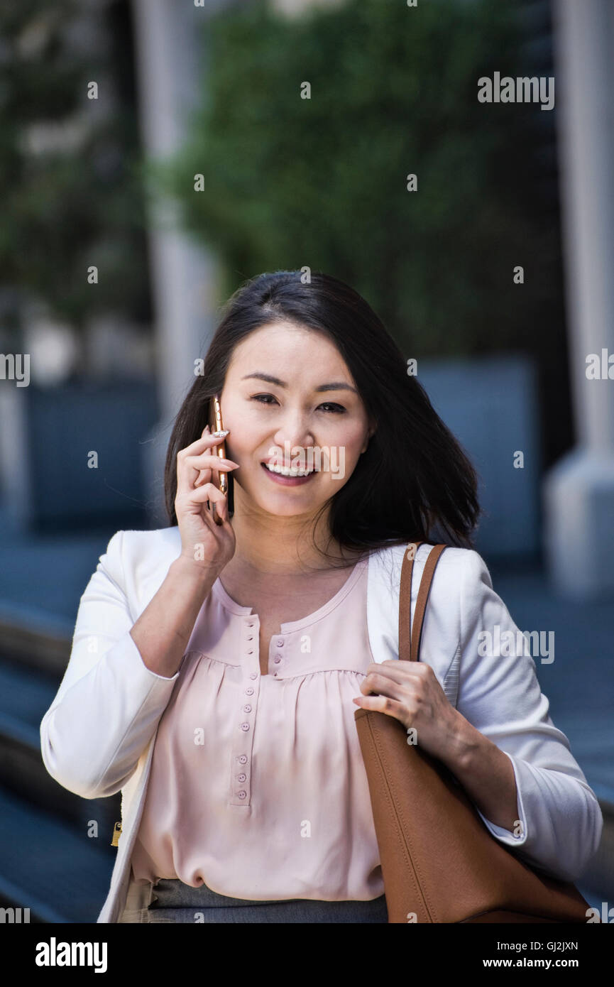 Geschäftsfrau, walking im Freien, mit Smartphone, Lächeln Stockfoto