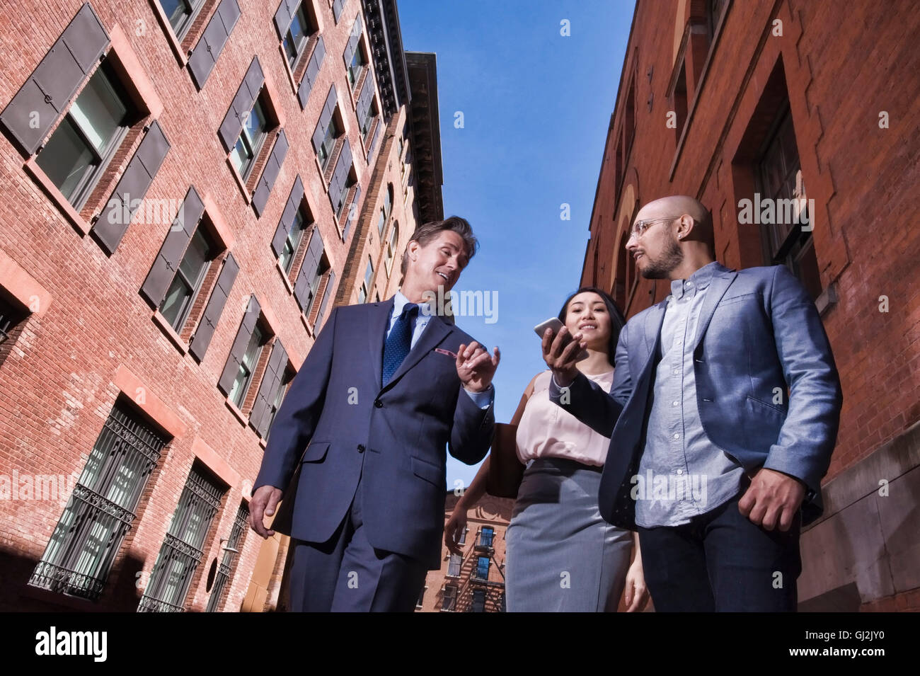 Unternehmerinnen und Unternehmer walking im Freien, niedrigen Winkel Ansicht Stockfoto