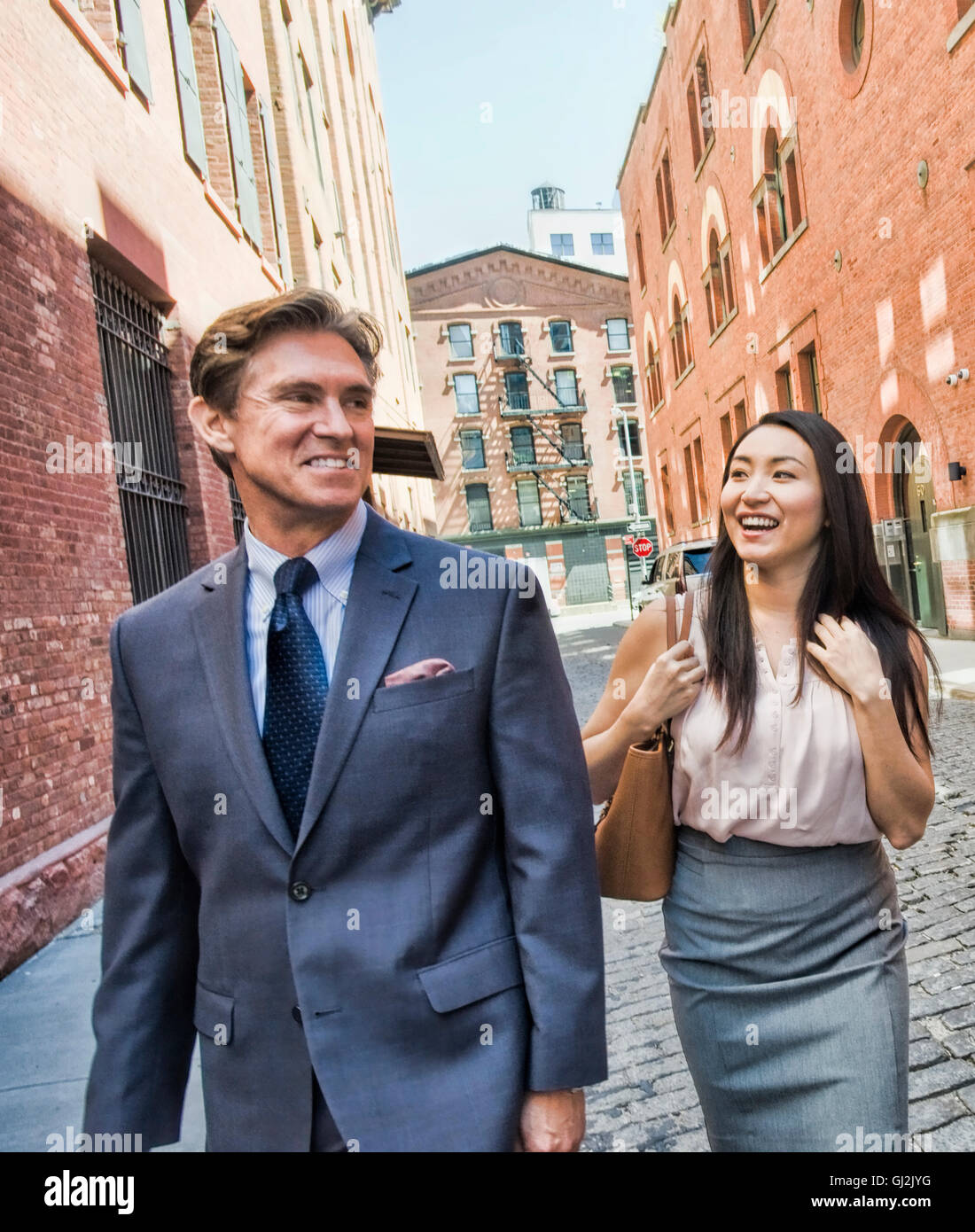 Geschäftsmann und Frau zu Fuß zusammen, in der Straße, Lächeln Stockfoto