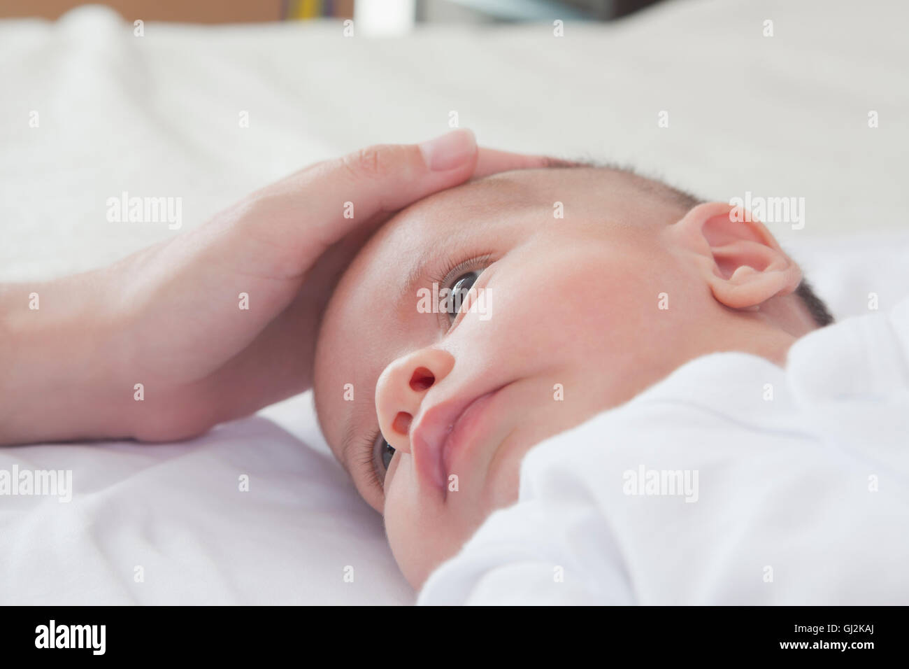 Mütter Hand streichelte Baby jungen Kopf Stockfoto