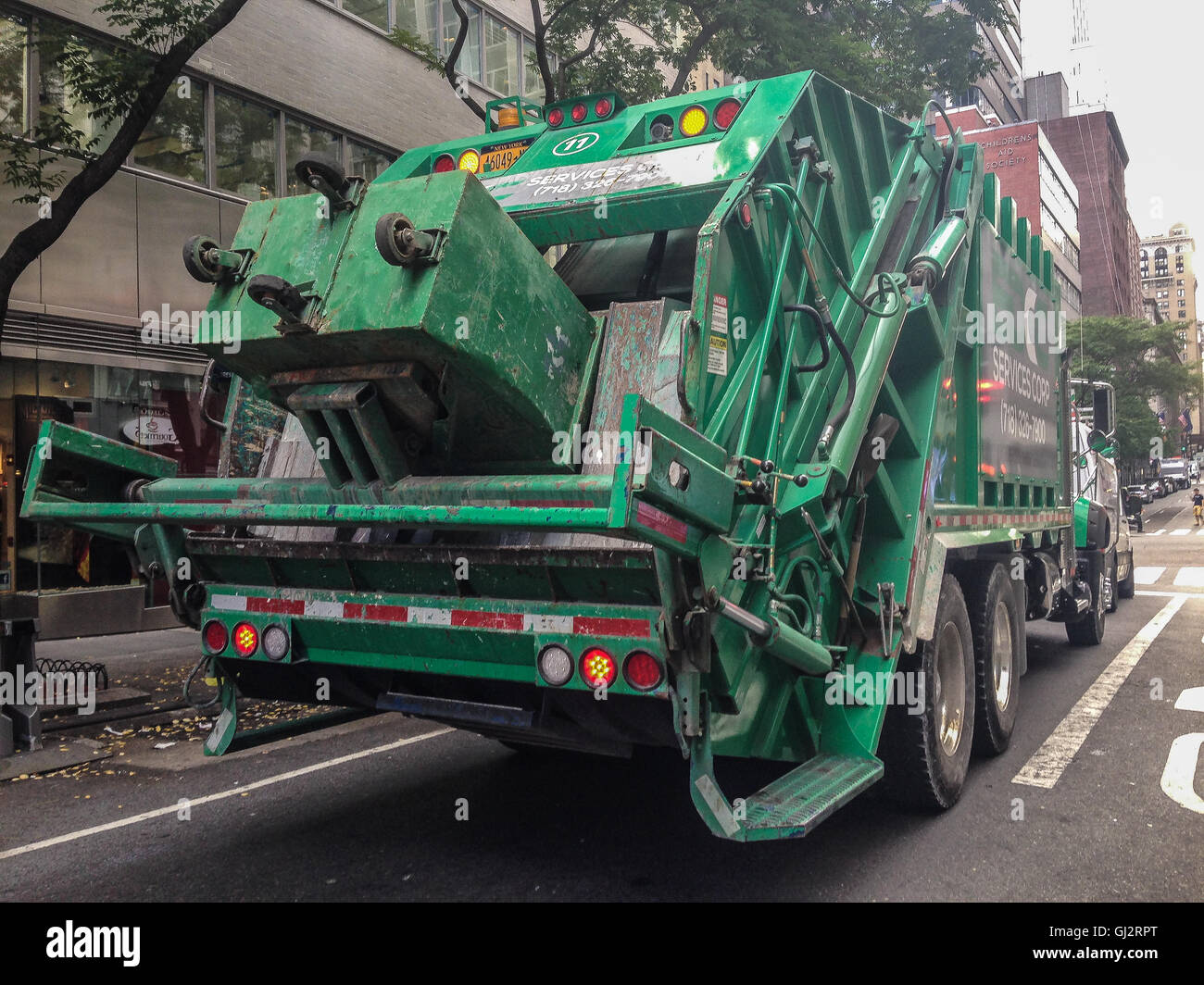 Eine grüne Müllwagen hat an einer Ampel in Manhattan gestoppt. Stockfoto