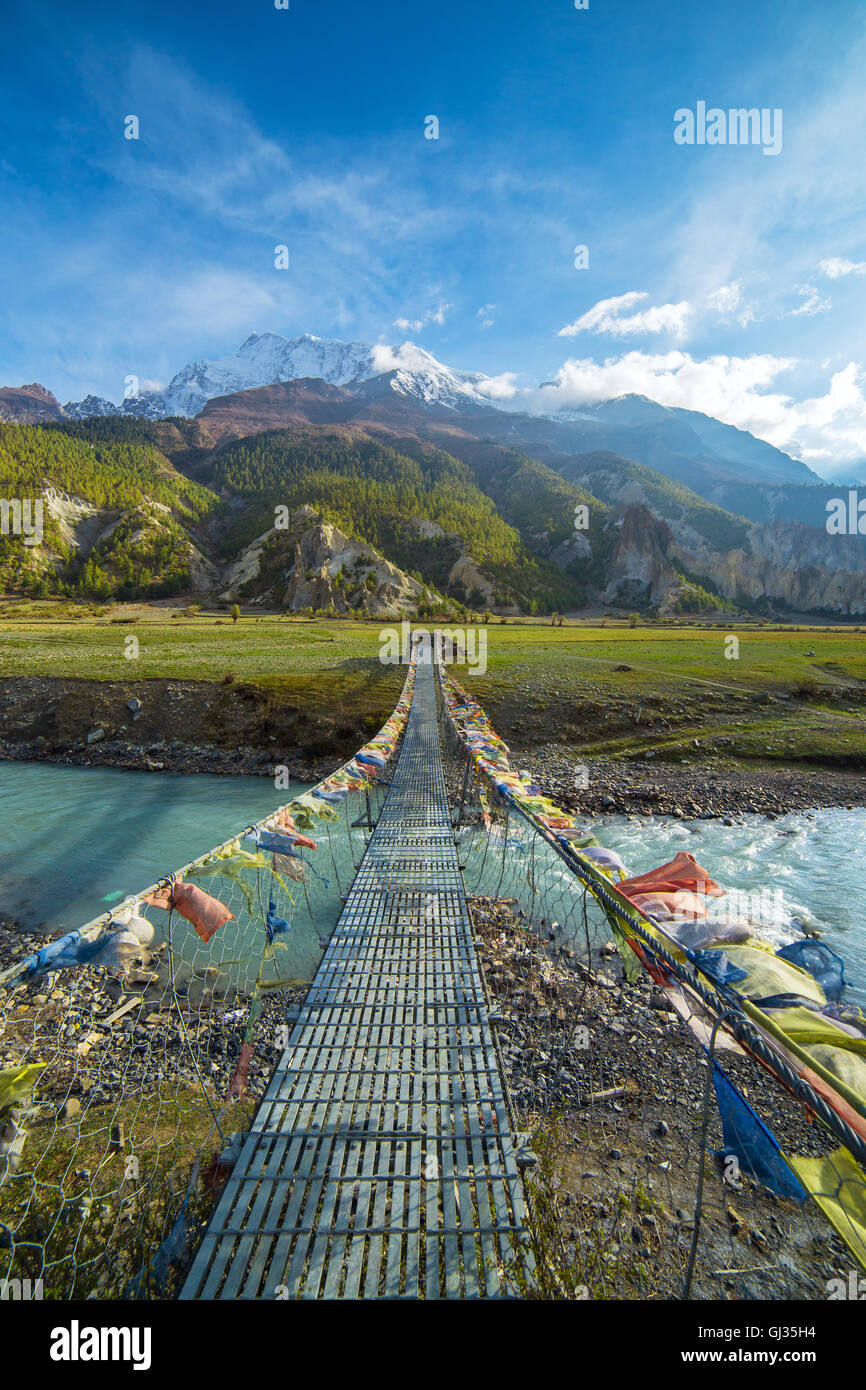 Hängebrücke mit buddhistischen Gebetsfahnen auf dem Annapurna Circuit trek in Nepal Stockfoto