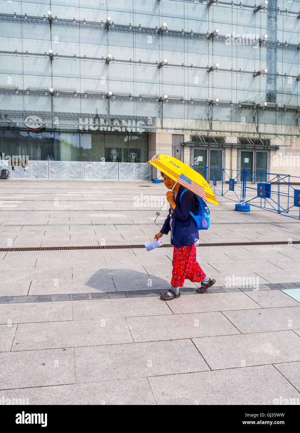 Eine alte Frau, einzigen weiblichen Pilger gehen allein auf World Youth Day 2016 Ereignis in Krakau / Polen mit einem gelben Regenschirm Stockfoto
