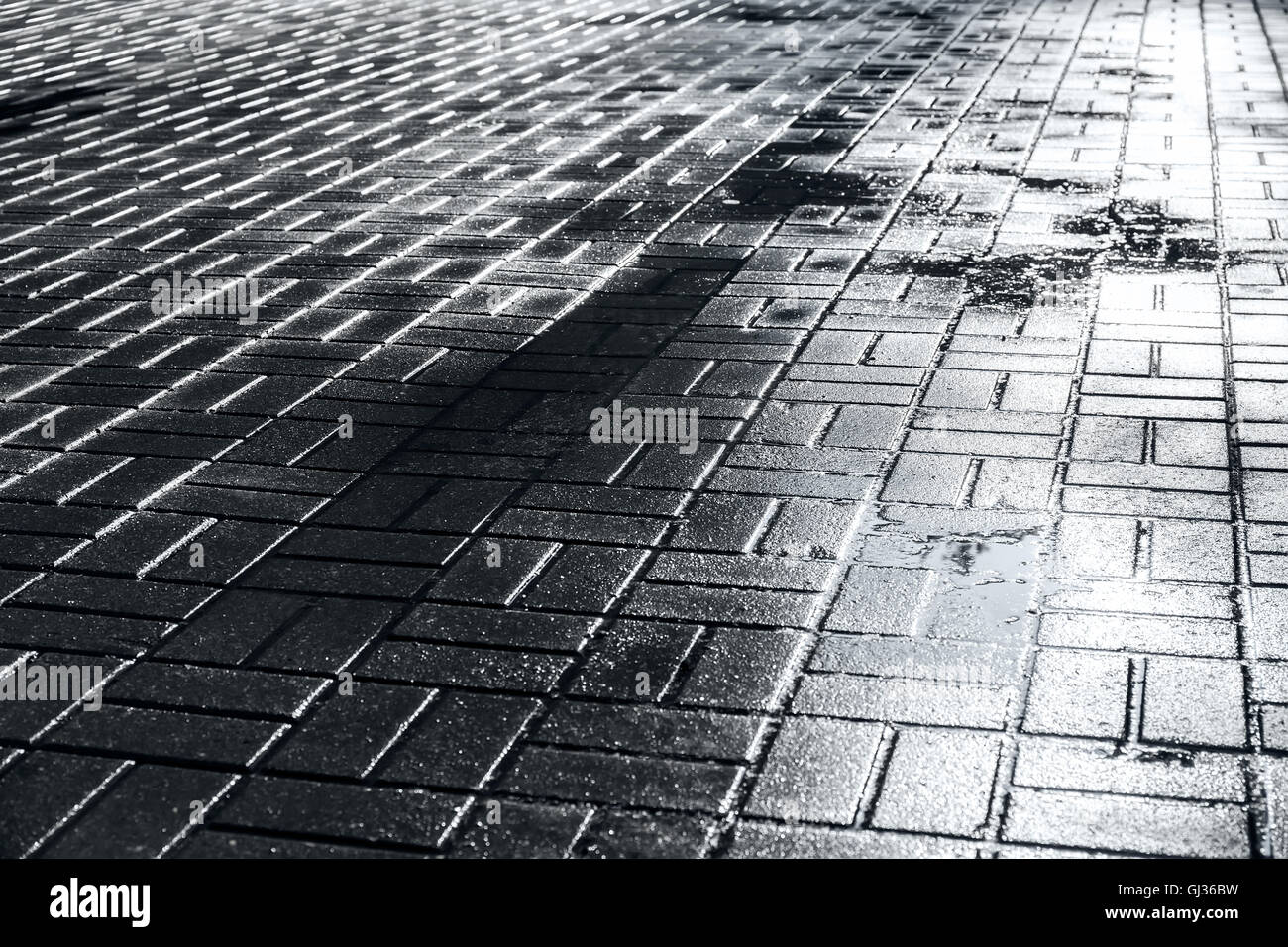 glänzenden nassen Kopfsteinpflaster Bürgersteig abstrakte städtische Straße Hintergrund Stockfoto