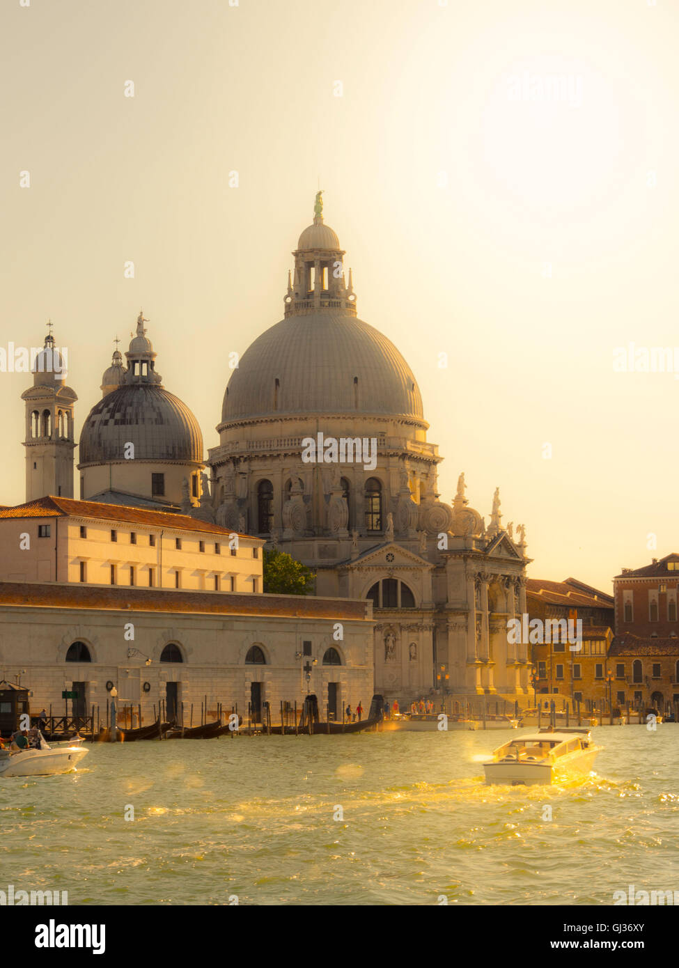 St. Maria della Salute bei Sonnenuntergang, mit Booten über den Canale Grande. Venedig, Italien. Stockfoto