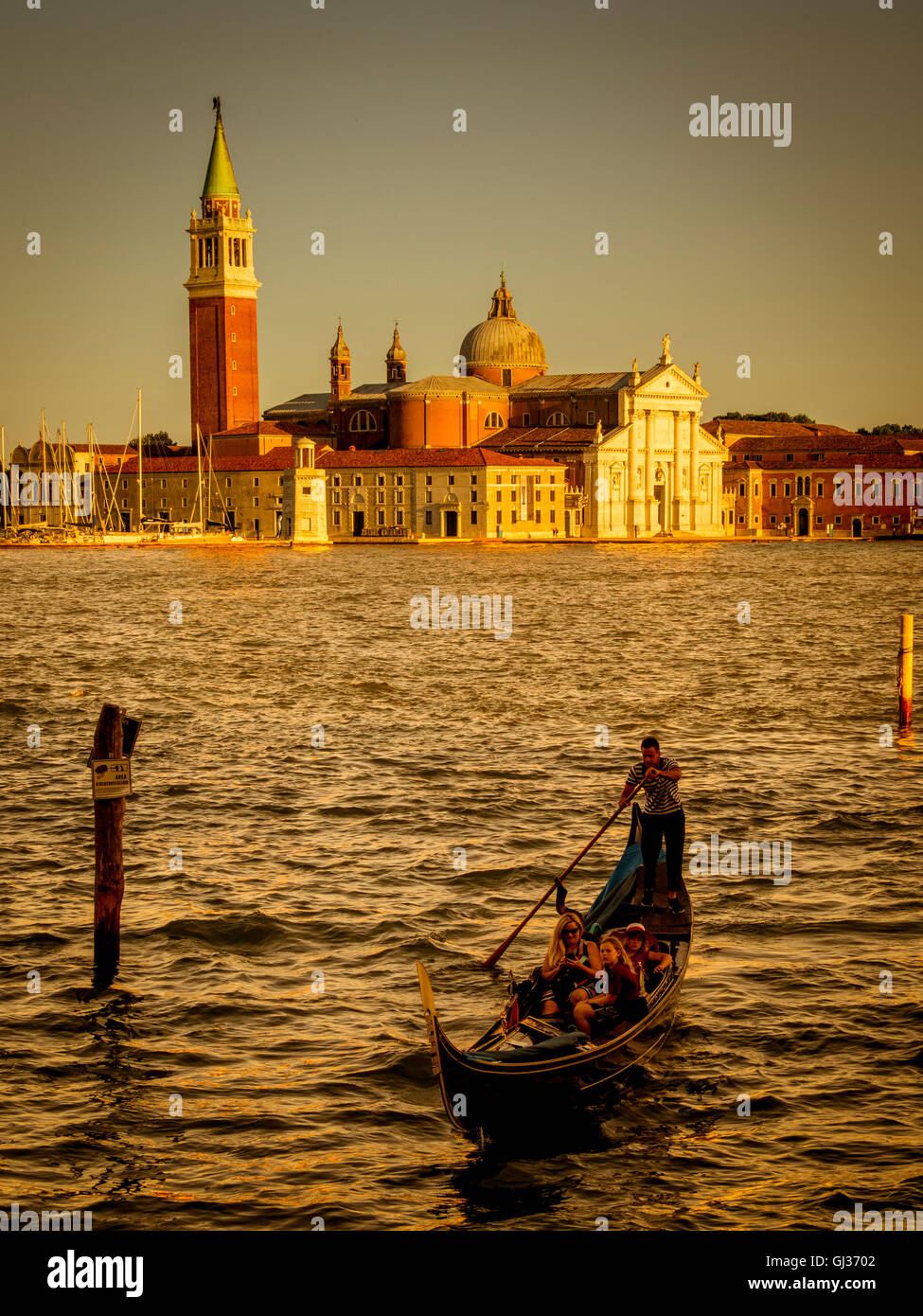 Einzelne Gondel Canale di San Marco, bei Sonnenuntergang mit der Insel San Giorgio Maggiore im Hintergrund. Venedig, Italien. Stockfoto