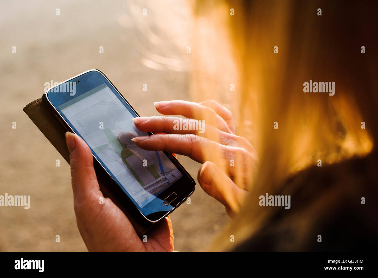 Junge Frau im Freien, mit Smartphone, close-up Stockfoto