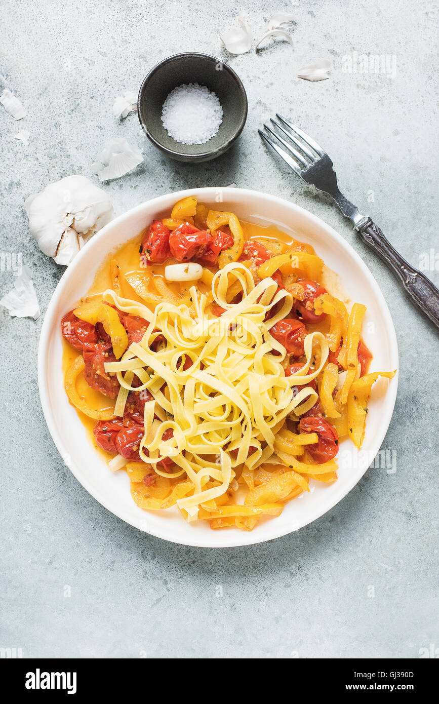 Pasta Tagliatelle mit Cherry-Tomaten-Sauce und Knoblauch auf weißen Teller Stockfoto