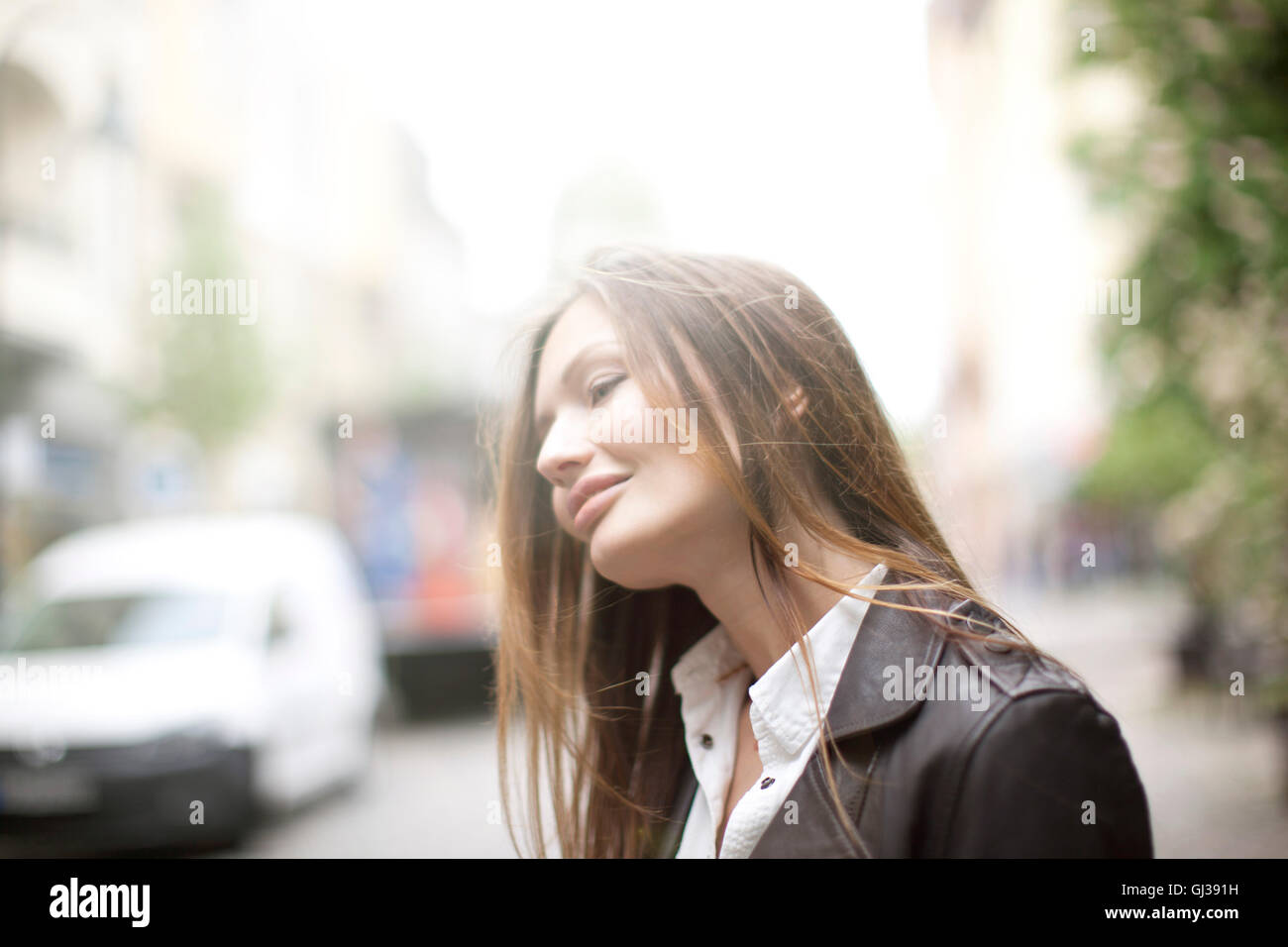 Schöne Frau mit langen braunen Haaren auf Stadtstraße Stockfoto