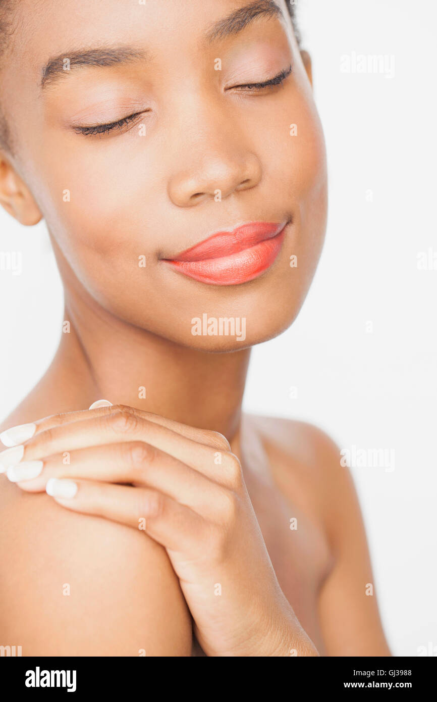 Frau trägt Lippenstift, Hand auf Schulter, Augen geschlossen Stockfoto