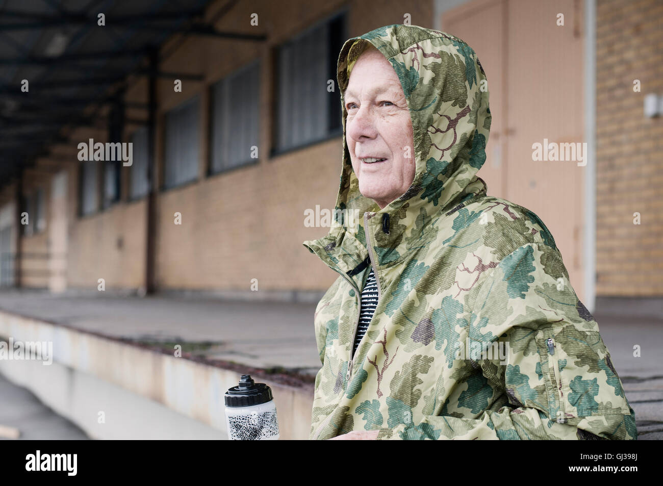 Mann, tragen Camouflage wasserdicht Kapuzenmantel wegschauen Stockfoto