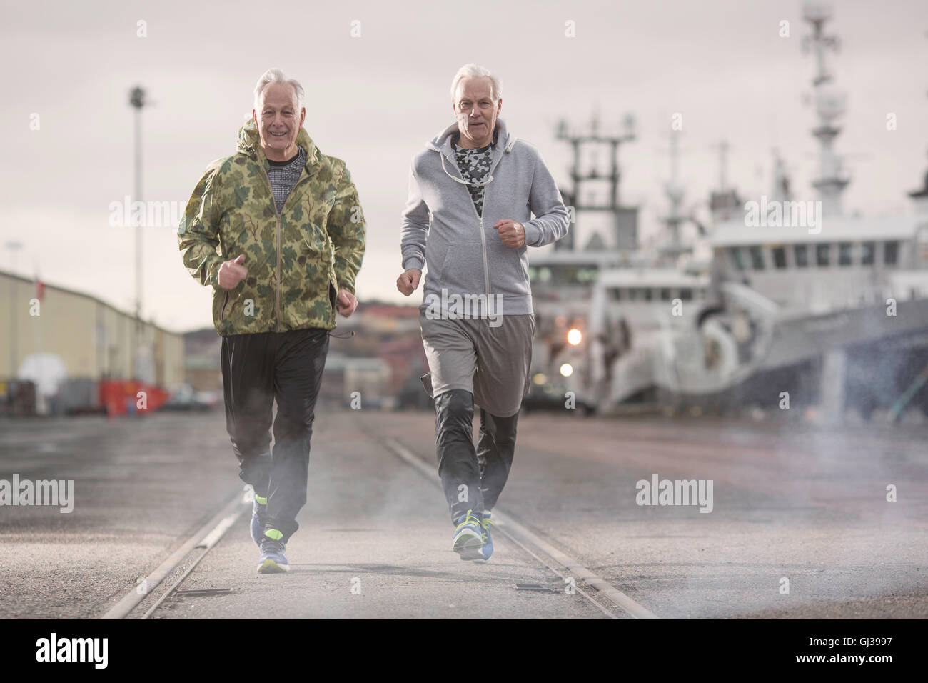 Vorderansicht der Männer Joggen auf docklands Stockfoto