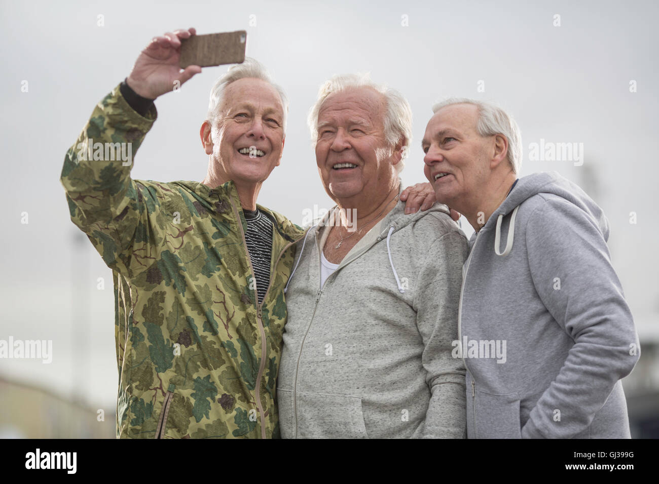 Senioren Freunde tragen Sportkleidung mit Smartphone zum Selfie nehmen Stockfoto