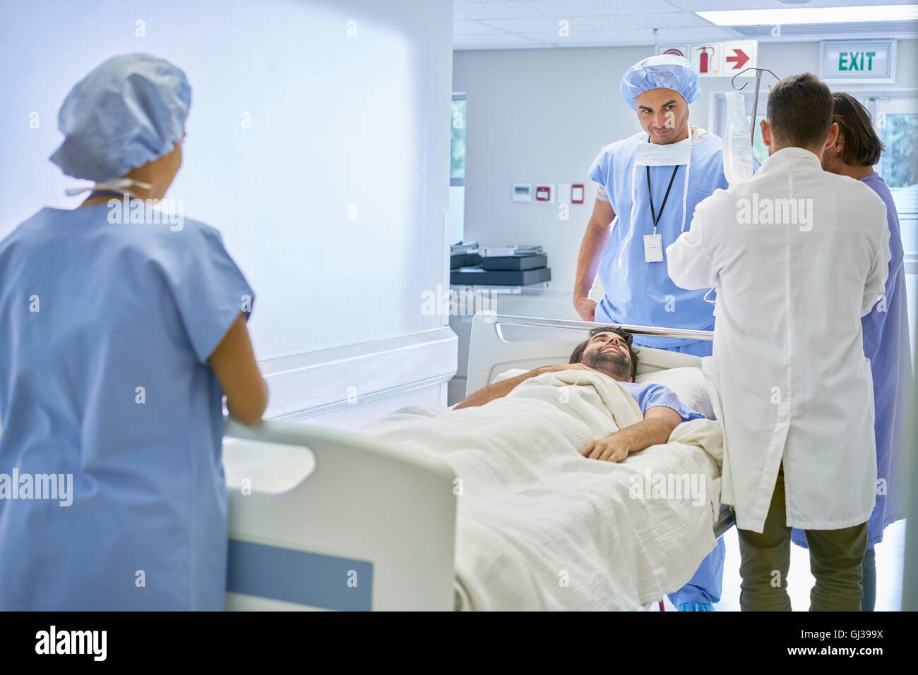 Ärzte um Patienten im Krankenhausbett Stockfoto