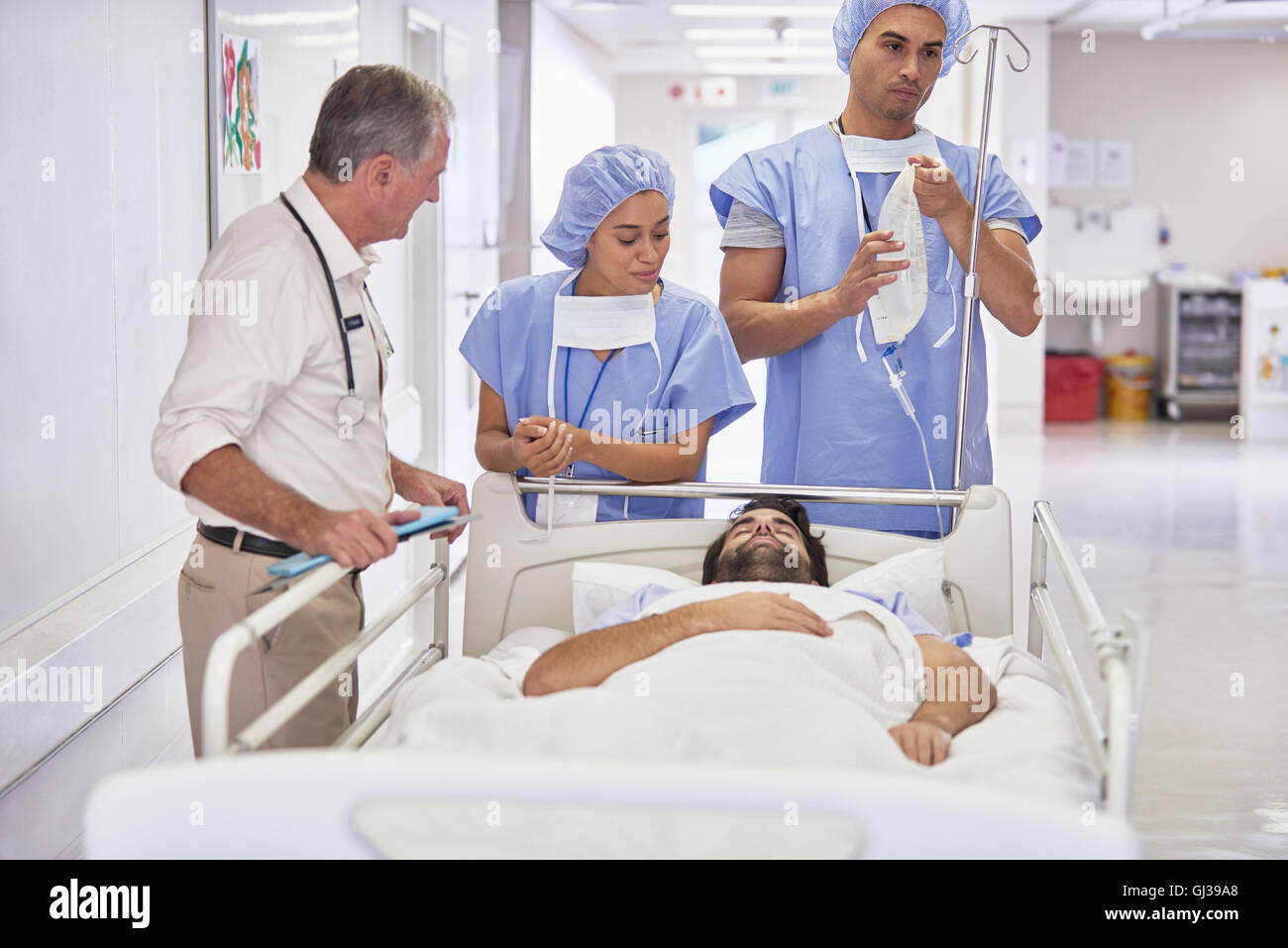 Ärzte um Patienten im Krankenhausbett Stockfoto