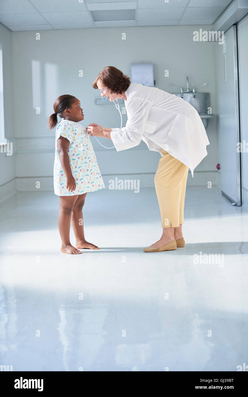 Ärztin mit Stethoskop auf Mädchen im Krankenhaus Kinderstation Stockfoto