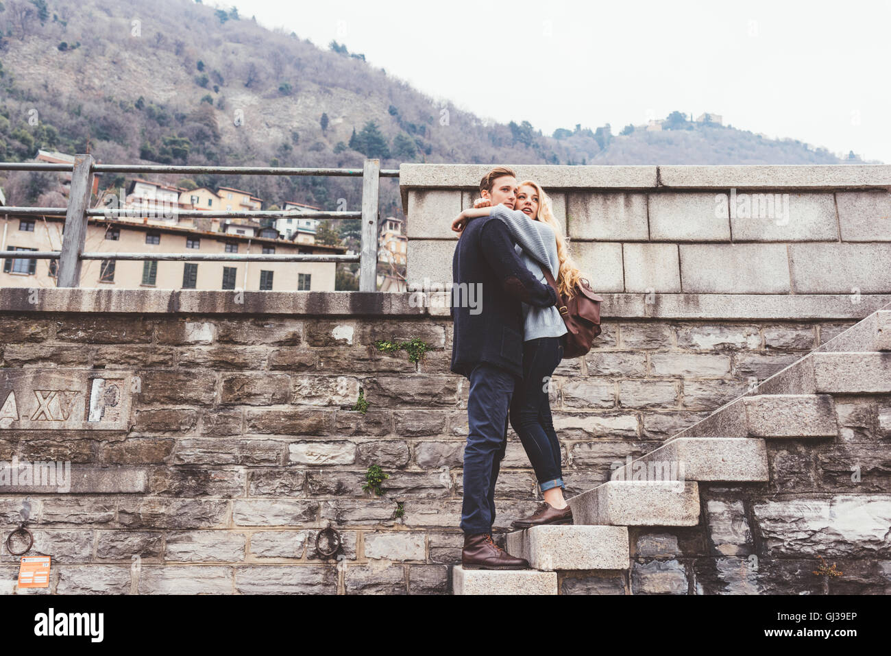 Junges Paar umarmt Hafen Wand Schritte, Comer See, Italien Stockfoto