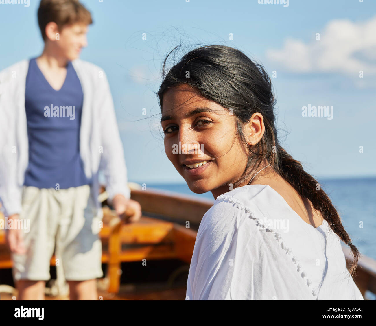 Frau auf Boot über Schulter schaut in die Kamera Lächeln Stockfoto