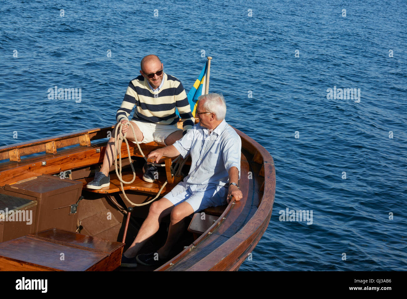 Freunde sitzen im Boot am Ozean Stockfoto