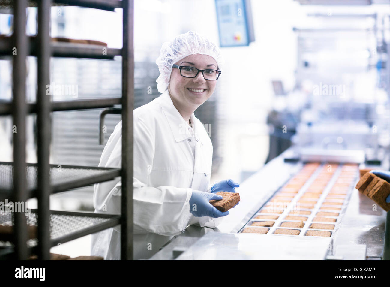 Fabrikarbeiter auf Lebensmittelproduktionlinie Blick auf die Kamera zu Lächeln Stockfoto