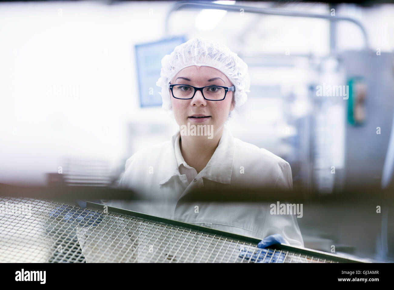 Fabrikarbeiter, Haarnetz Blick auf Kamera Lächeln auf den Lippen tragen Stockfoto