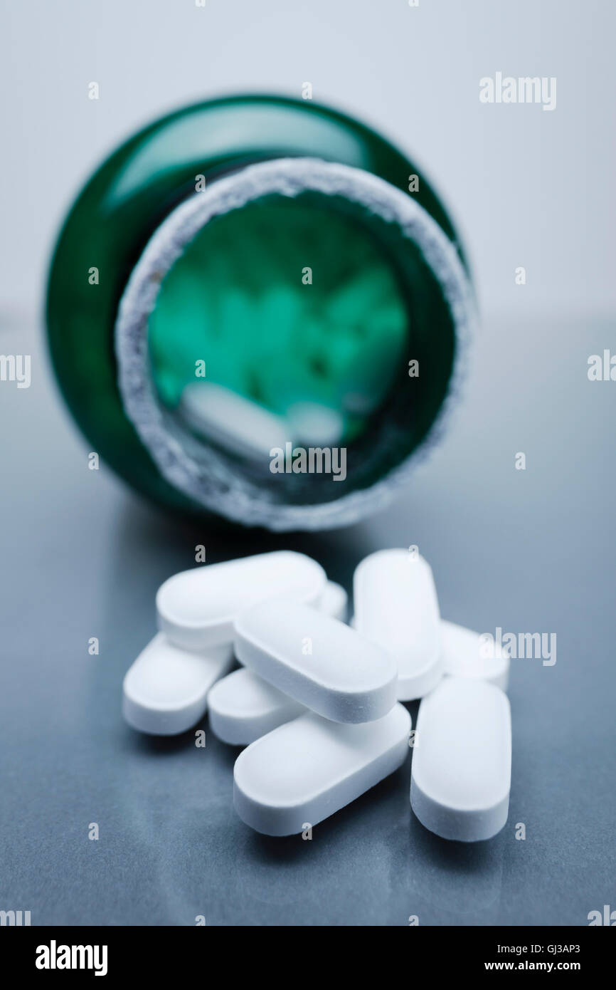 Ovale Tabletten durch grüne Pille Flasche Stockfotografie - Alamy