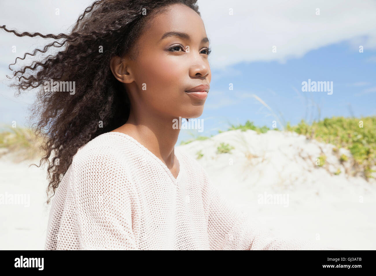 Junge Frau am Strand an windigen Tag Stockfoto