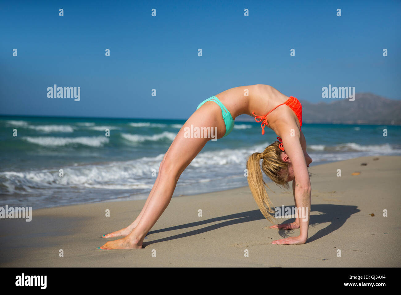 Junge Frau am Strand, Sport, riss sich ein Bein Stockfoto