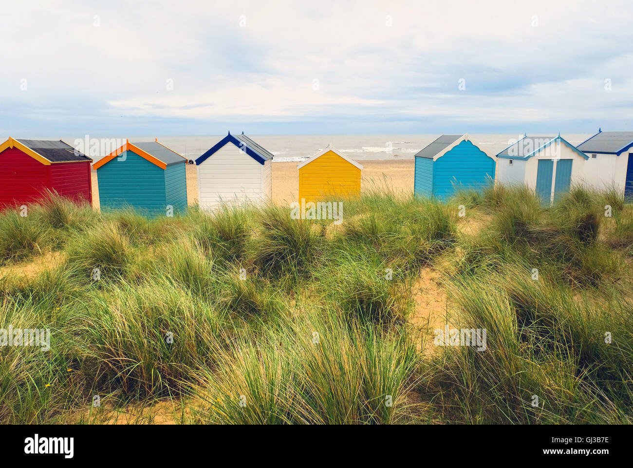 Rückansicht des eine Zeile mehrfarbige Strandhütten in Sanddünen, Southwold, Suffolk, Großbritannien Stockfoto