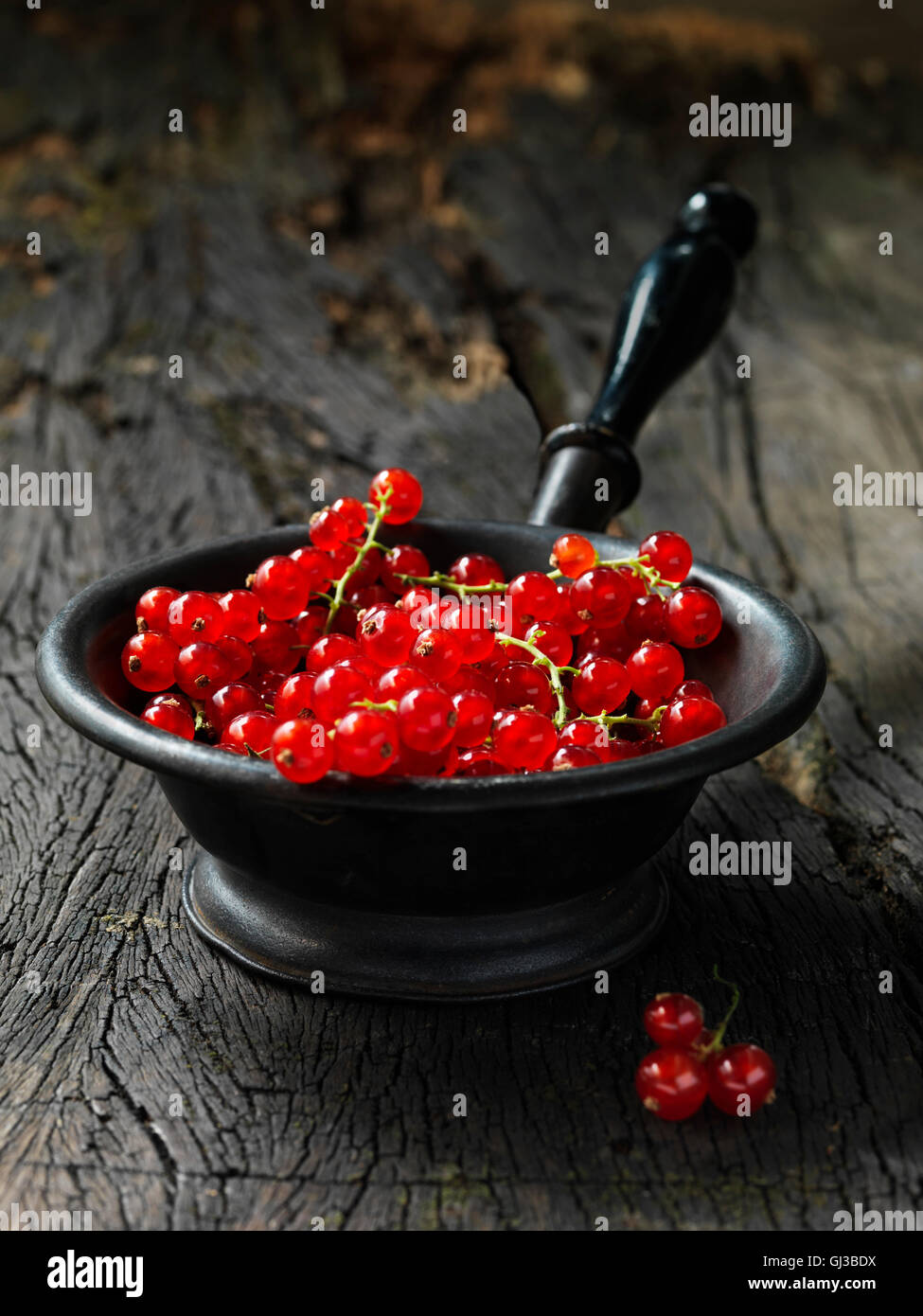 Rote Johannisbeeren in kleinen Vintage Metallsieb, rustikalen Holztisch Stockfoto