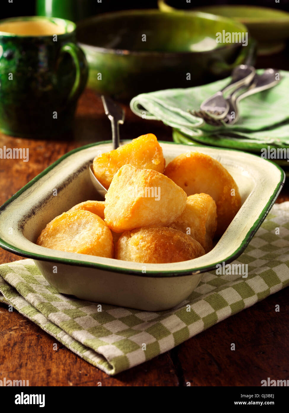 Goldene Bratkartoffeln in Vintage Schüssel, Holztisch Stockfoto