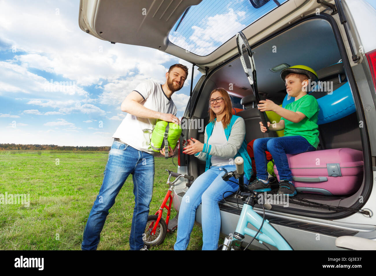 Junge Familie laden Kofferraum für die Autofahrt Stockfoto