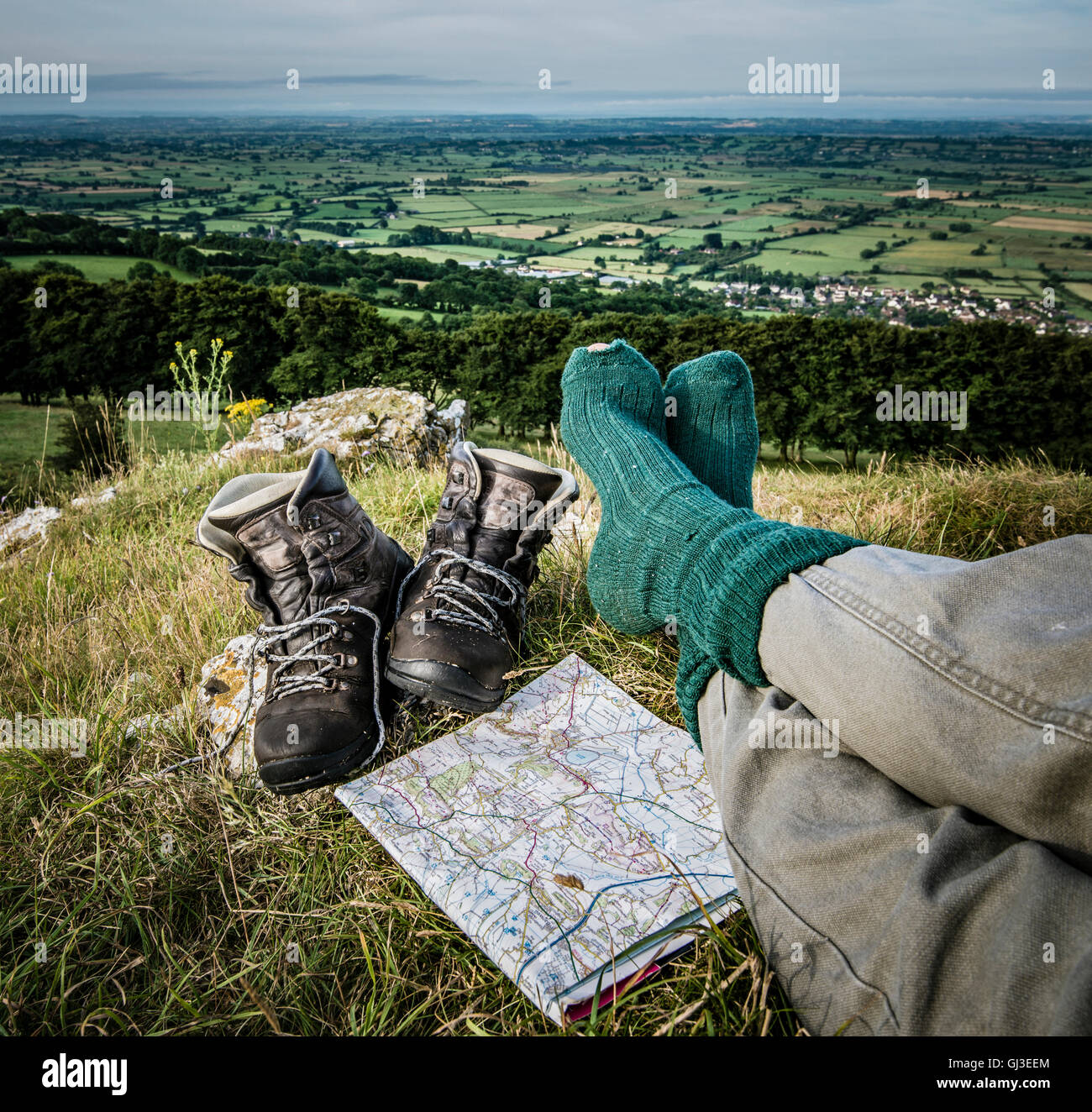 Müde Wanderer nimmt eine Auszeit auf einem Hügel-Aussichtspunkt. Stockfoto