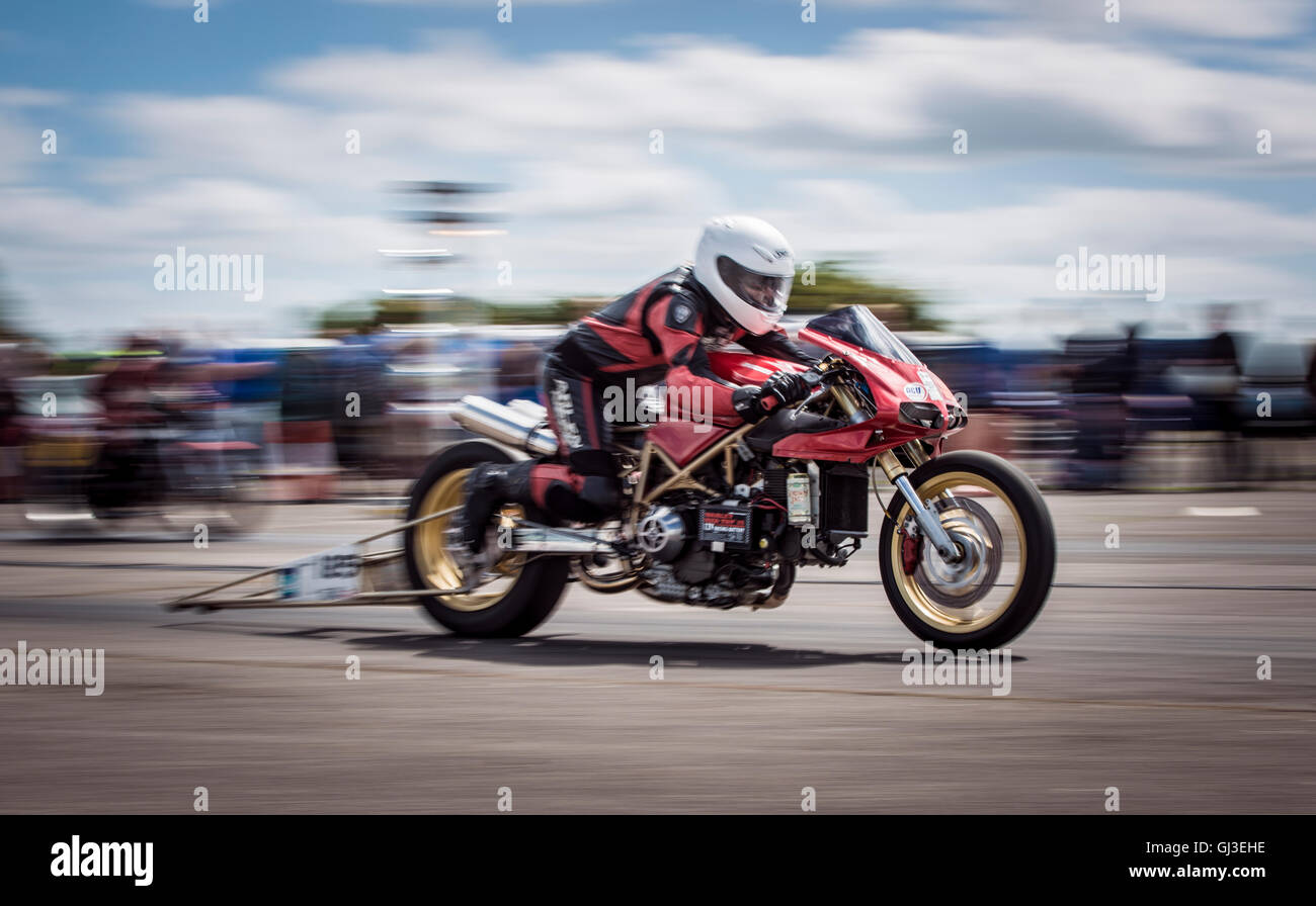 Ein speziell dafür gebauten Drag Bike zeigt seine extreme Beschleunigung, wie es auf der Linie gestartet wird. Stockfoto