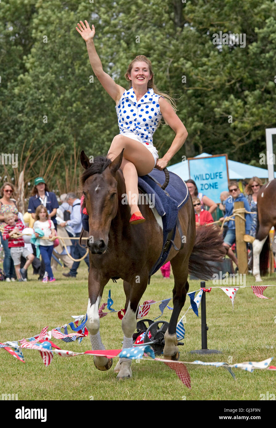 Menschenmassen sehen Mädchen darstellende Akrobatik auf zurück galoppierenden Pferd Galloping Akrobatik Countryfile Live Blenheim UK Stockfoto