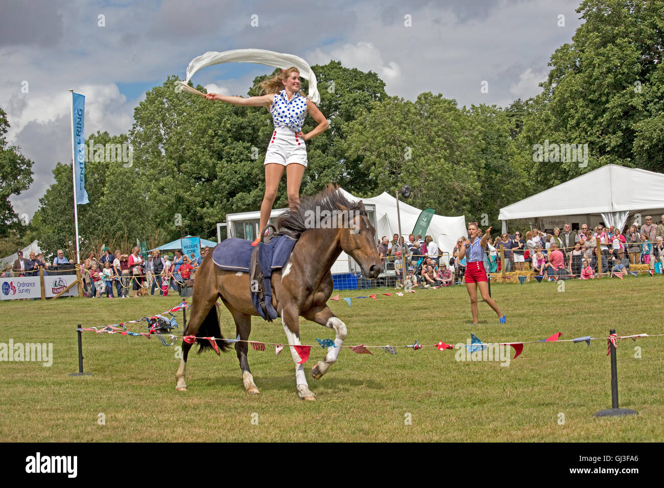 Menschenmassen sehen Mädchen stehen auf zurück galoppierenden Pferd Countryfile Live Blenheim UK Stockfoto