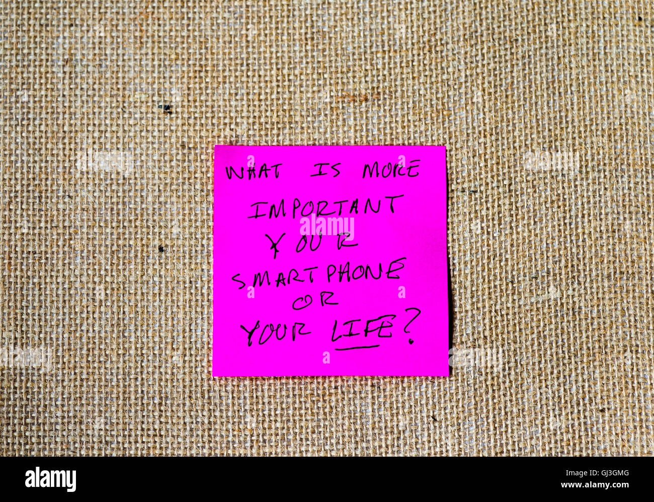 Satz "Was ist wichtiger, Ihr Smartphone oder Ihr Leben?" geschrieben auf Haftnotizen Stockfoto