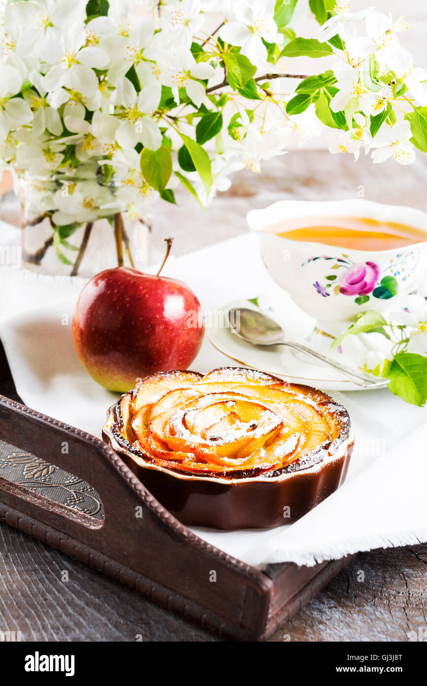 Apple stieg geformte Kuchen und eine Tasse Tee auf der Vintage Serviertablett. Frühstückstee mit süßen Apfel Gebäck. Apfelkuchen für Stockfoto