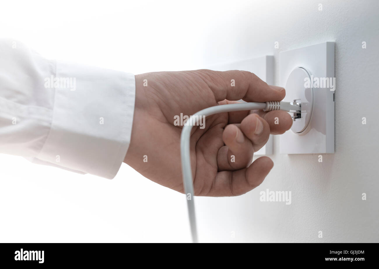 Nahaufnahme einer Hand stecken ein Ethernet Kabel in die Steckdose, Bild horizontal. Konzept der Broadband Network Stockfoto
