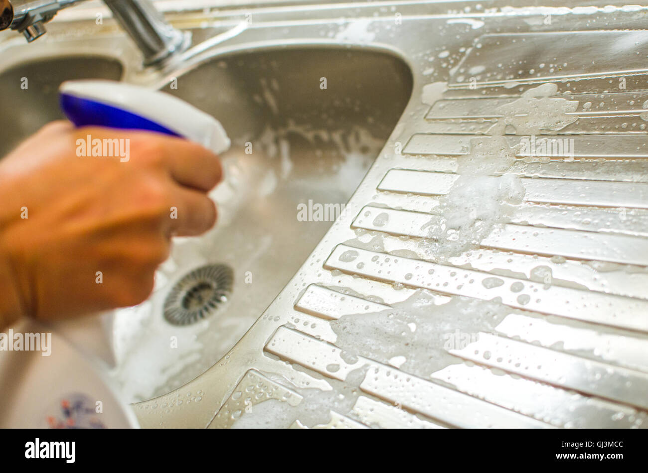 Hand-Spray Reinigungsmittel auf Küche Spüle Hausarbeit Hauswirtschaft Stockfoto