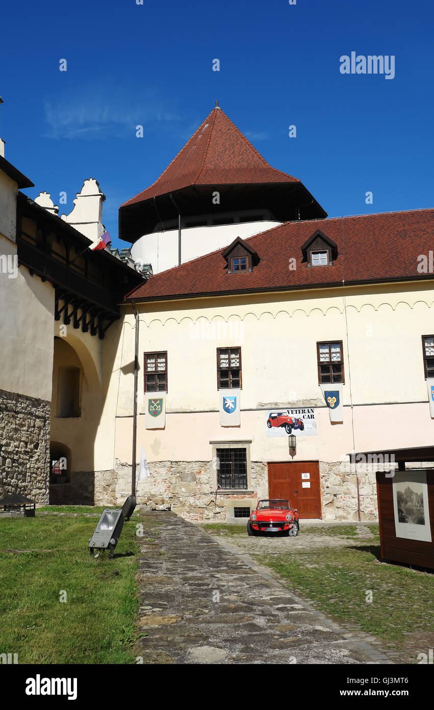 KEZMAROK, Slowakei - 8. Juli 2016: Der Turm und rote englische Oldtimer in Kezmarok Burg, hohe Tatra, Slowakei. Stockfoto