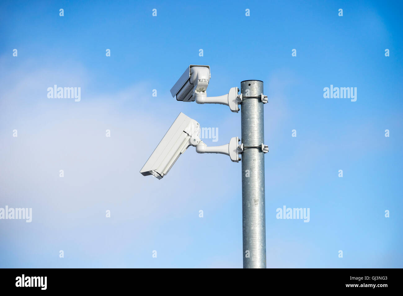 Twin-Überwachungskameras auf einem Pfahl gegen ein blauer Himmel und trübe Wolke Stockfoto