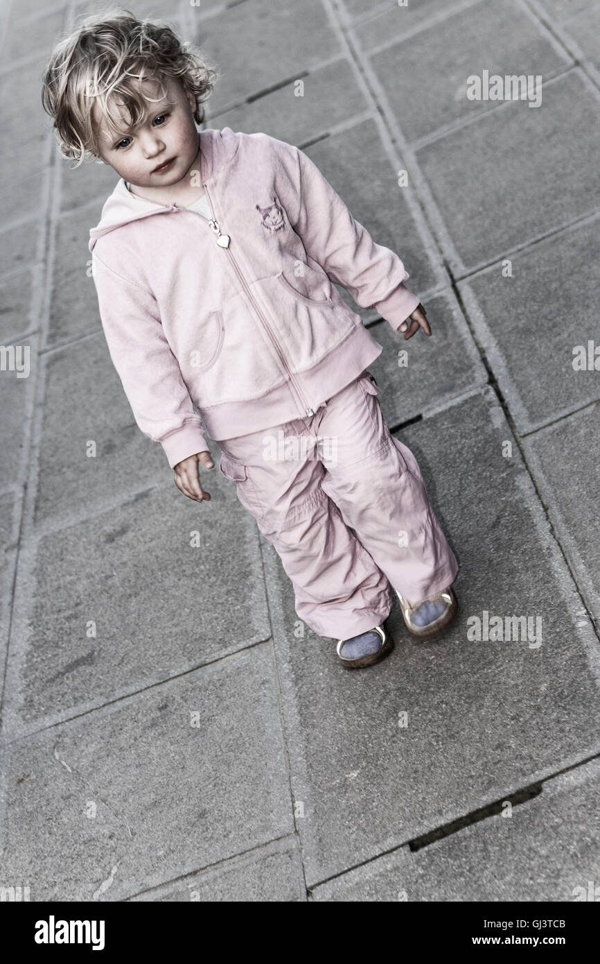 Kind läuft allein auf Straße Stockfoto