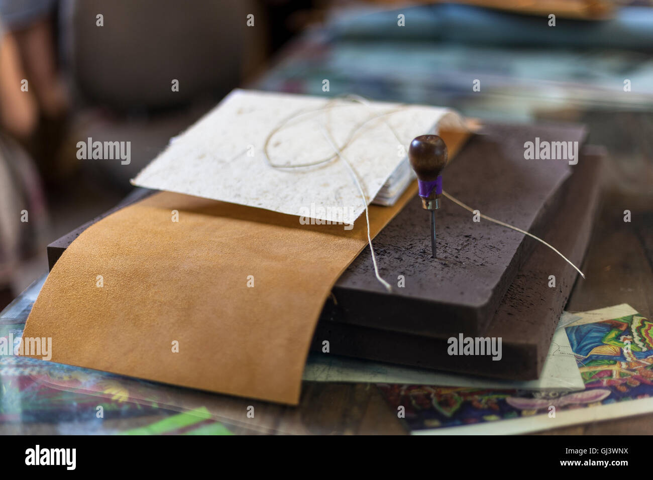 Buchbinder legt Werkzeuge in Vorbereitung für das Nähen. Stockfoto