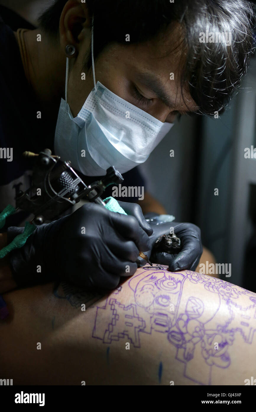 Pasay City, Philippinen. 12. August 2016. Ein Künstler tattoos ein Kunde während der jährlichen Philippine Tattoo-Expo in Pasay City, Philippinen, 12. August 2016. Der philippinischen Tattoo Expo ist eine jährliche Veranstaltung, wo gefeiert Tattoo-Künstler und Enthusiasten zu sammeln, zu bezeugen und in Tattoo-Wettbewerben teilnehmen. Bildnachweis: Rouelle Umali/Xinhua/Alamy Live-Nachrichten Stockfoto