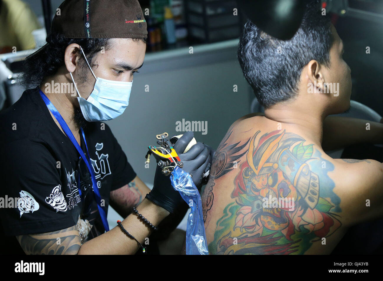 Pasay City, Philippinen. 12. August 2016. Ein Künstler tattoos ein Kunde während der jährlichen Philippine Tattoo-Expo in Pasay City, Philippinen, 12. August 2016. Der philippinischen Tattoo Expo ist eine jährliche Veranstaltung, wo gefeiert Tattoo-Künstler und Enthusiasten zu sammeln, zu bezeugen und in Tattoo-Wettbewerben teilnehmen. Bildnachweis: Rouelle Umali/Xinhua/Alamy Live-Nachrichten Stockfoto